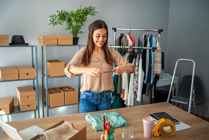 vrouw maakt foto van kledingstuk op een houten tafel voor haar eigen bedrijf